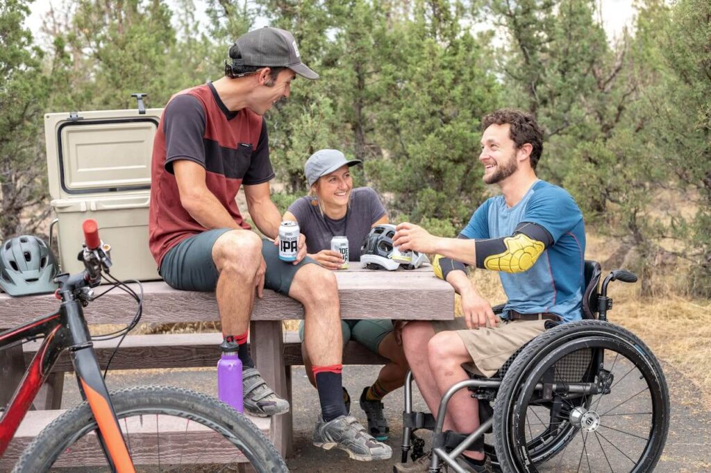 three friends one in a wheelchair having a picknick