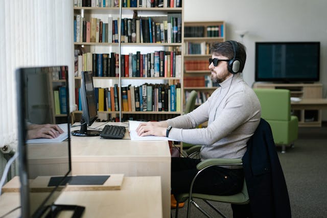 visual impaired, blind man using a hearing device on his computer