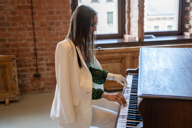 woman with a prosthetic arm playing the piano