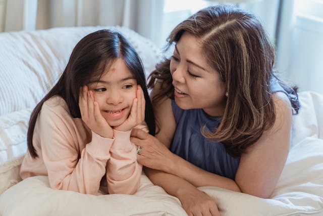 mother with a disabled child talking on the bed