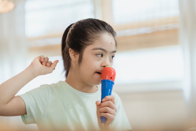 girl with downs syndrome singing in a toy microphone