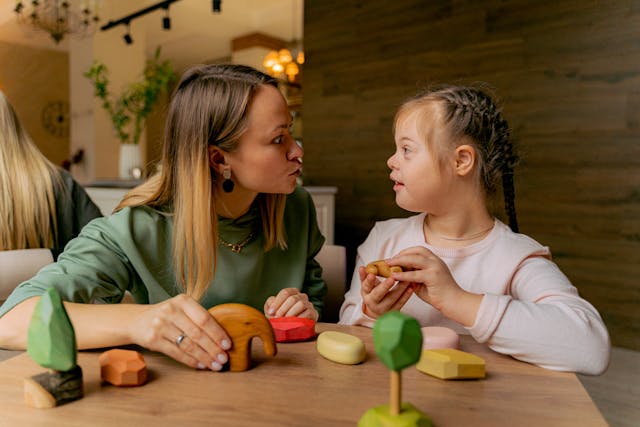 mother and daughter with downs syndrome playing with wooden blocks