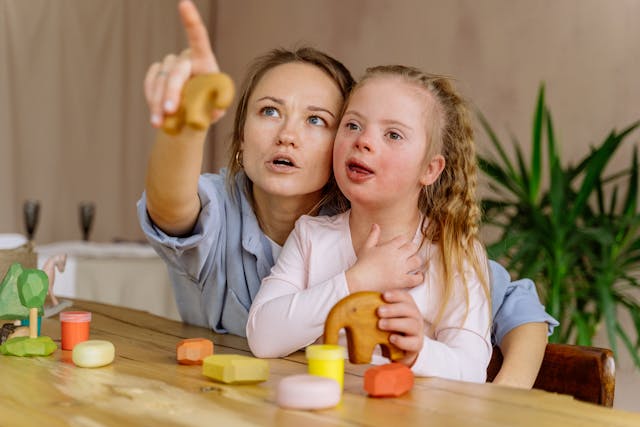 mother and her daughter with downs syndrome playing with wooden blocks