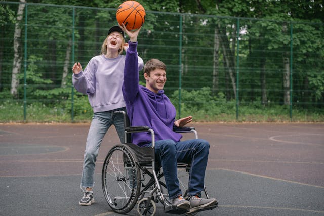 couple in a wheelchair playing basketball and laughing